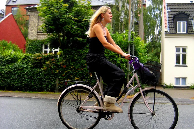 Woman riding bike in boots, no helmet