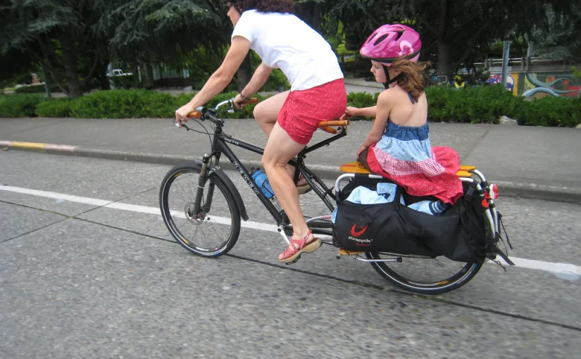 Mom cargo biking with daugher