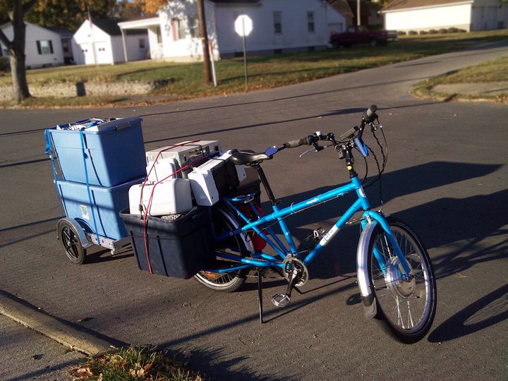 An electric Yuba Mundo cargo bike with a trailer full of e-waste