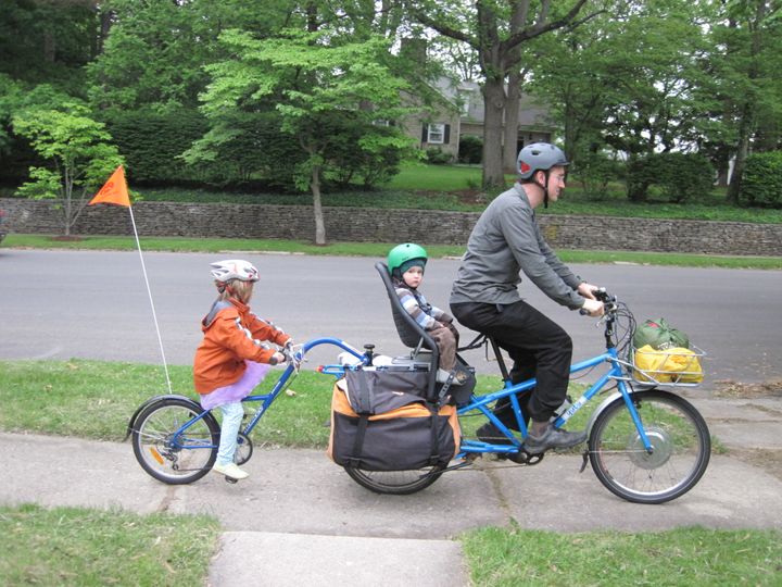 Dad with two kids and camping gear on an electric cargo bike