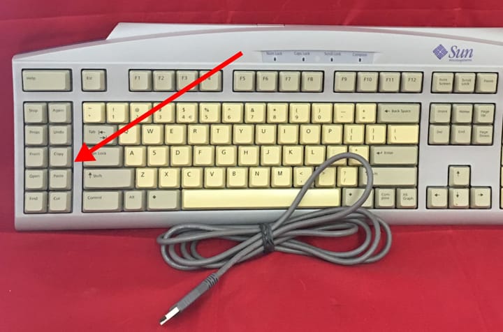 Vintage computer keyboard with arrow pointing to physical copy and paste keys